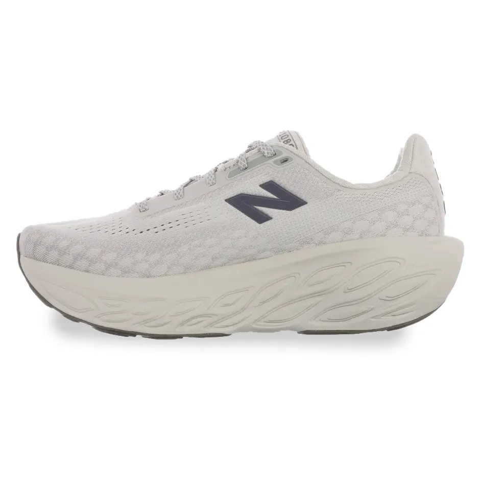 Vista lateral do tênis feminino New Balance 1080 V14 bege, destacando a malha respirável e a flexibilidade do cabedal.